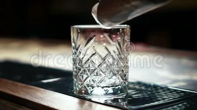 <strong>酒吧</strong>里的<strong>酒吧</strong>里，<strong>酒吧</strong>老板把冰块倒进桌子上的玻璃里。